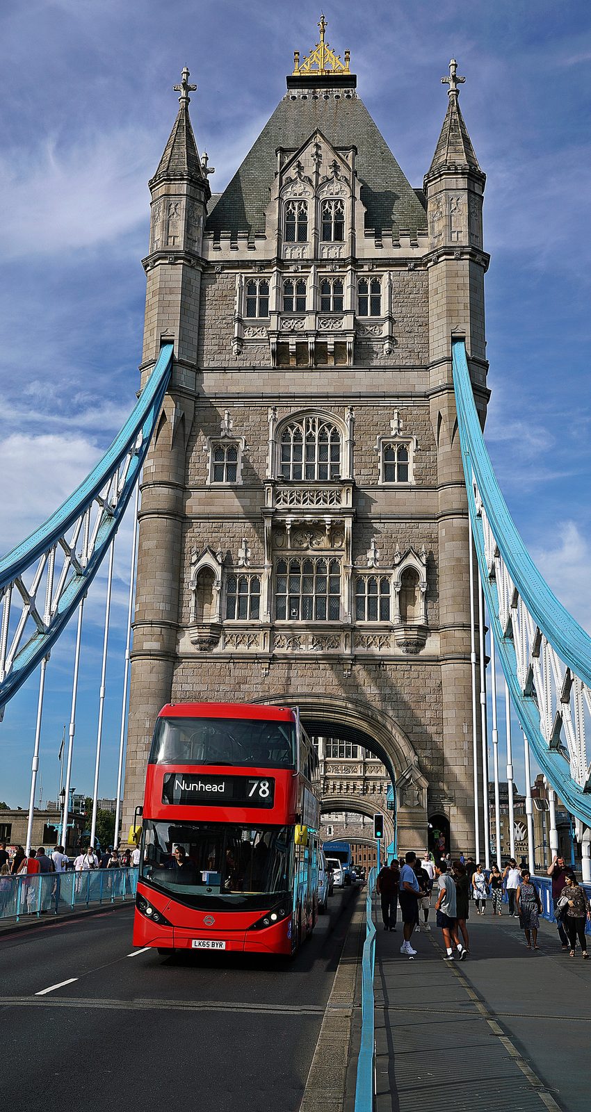 The north tower of Tower Bridge and its high-level walkways against a blue sky, daytime